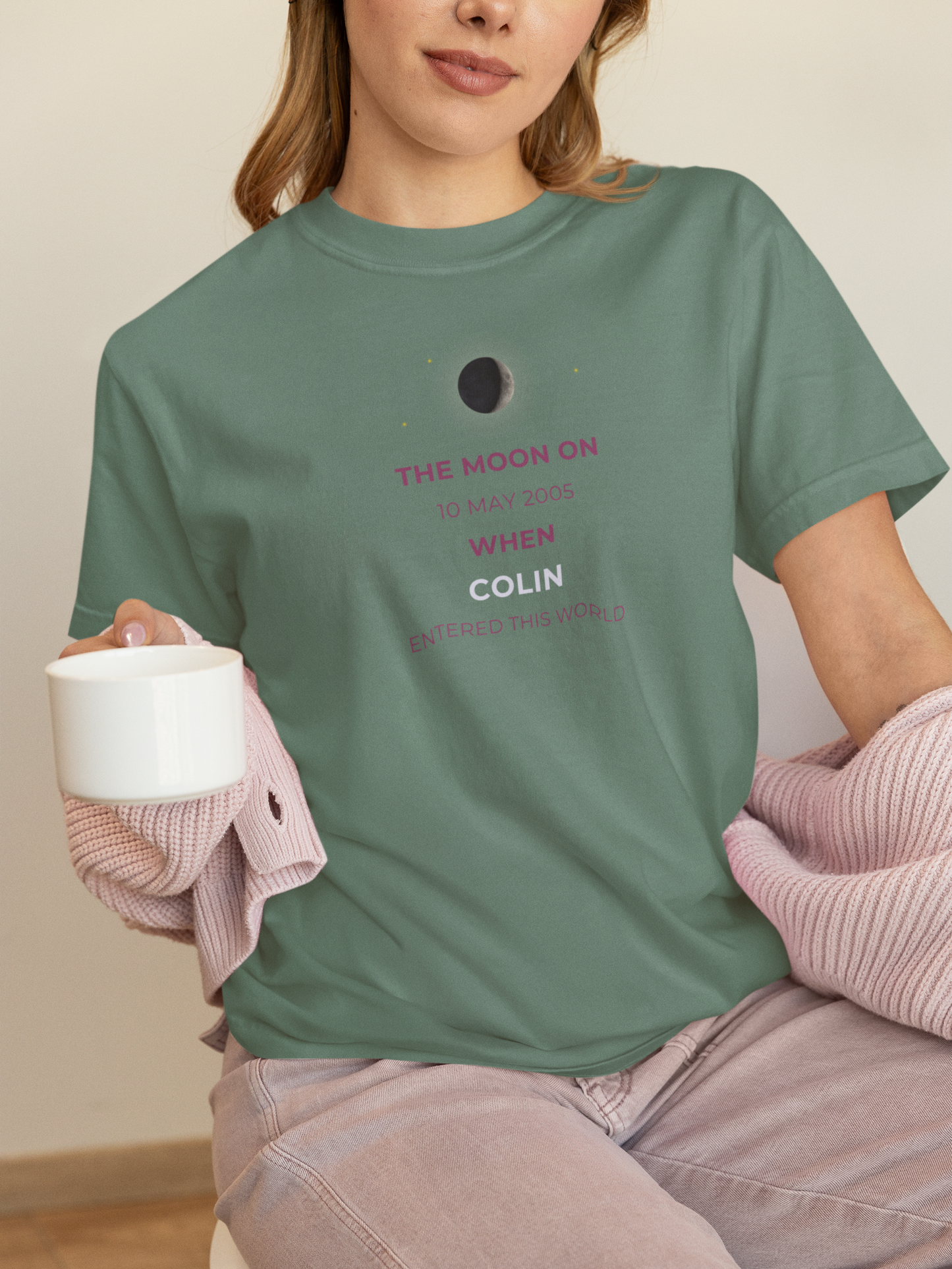 Person wearing a green t-shirt with text and holding a mug.