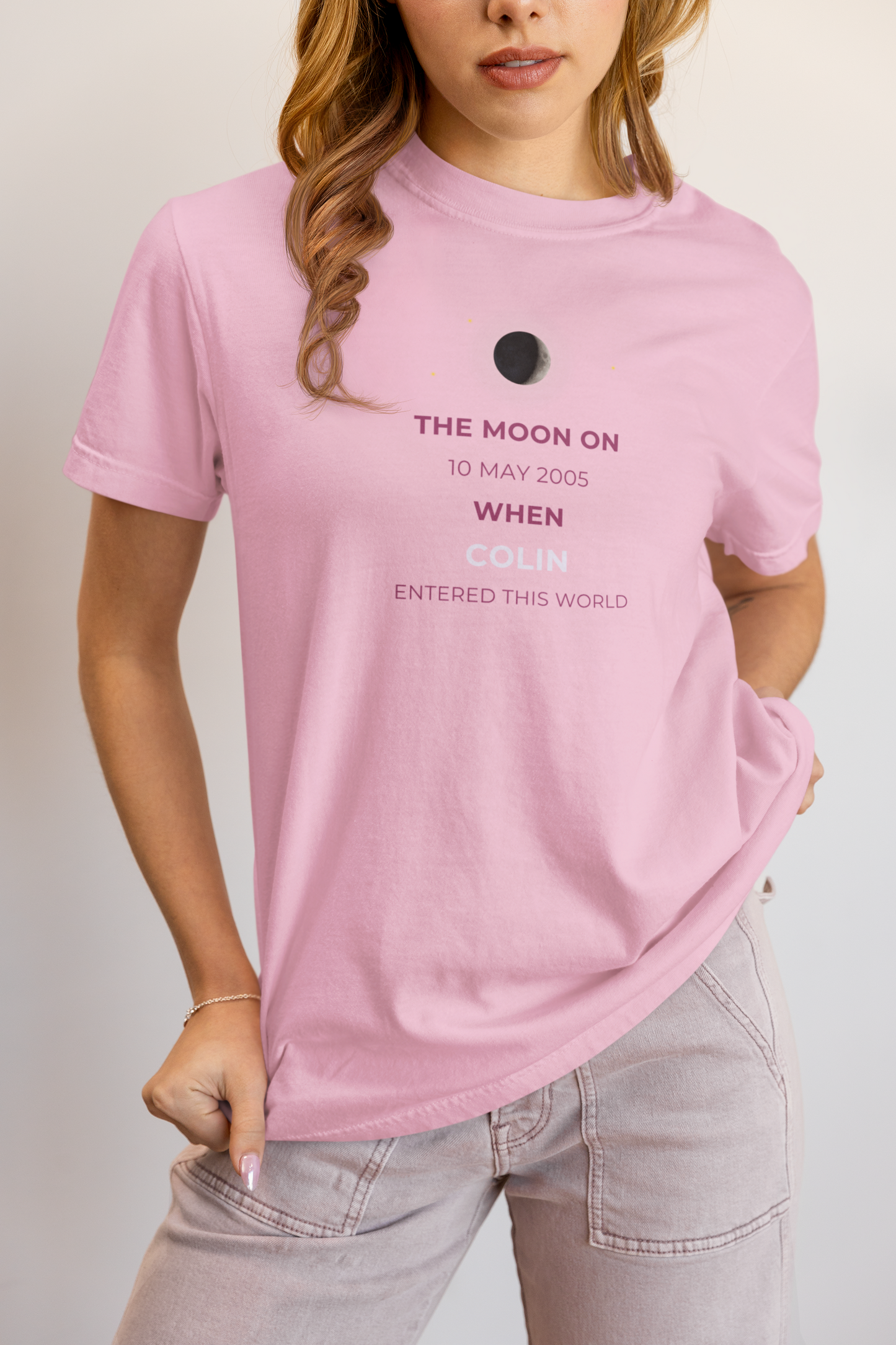 Person wearing a pink t-shirt with text on a plain background