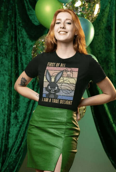 Woman wearing a black graphic T-shirt with a retro rainbow-colored design featuring a fierce bunny, Easter eggs, and the phrase “First of All, I Am a True Delight.” A bold and funny bunny shirt perfect for spring sass and chaotic energy.