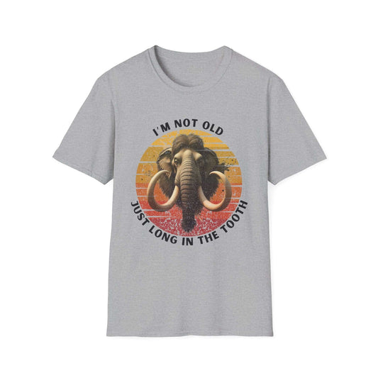 Unisex grey T-shirt with a vintage-style graphic of a woolly mammoth and a faded orange-blue sunrise background. Text reads “I’m not old, just long in the tooth.” Perfect for sarcastic birthday humor and dad jokes.