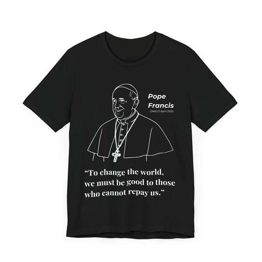 Black t-shirt with minimalist white portrait of Pope Francis wearing papal vestments and a halo. The quote, “To change the world, we must be good to those who cannot repay us,” is printed below. A commemorative Catholic shirt for tribute and inspiration.