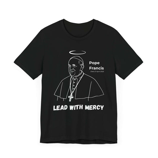Black shirt with bold white line art portrait of Pope Francis with halo, cross necklace, and the statement “Lead With Mercy.” A striking Catholic memorial shirt celebrating compassionate leadership.