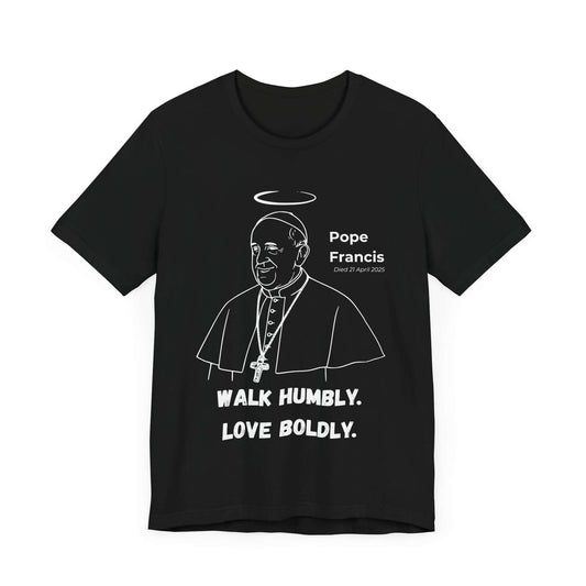 Black t-shirt featuring white line art of Pope Francis with halo, papal vestments, and cross. Below, the quote “Walk Humbly. Love Boldly.” A Catholic memorial design reflecting humble leadership and compassion.