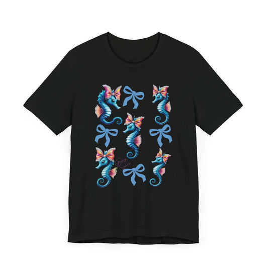 Black tee with a symmetrical pattern of cute, colorful seahorses and elegant bows arranged in a grid layout. The design radiates soft girl energy, vintage whimsy, and undersea coquette vibes — ideal for bold apparel and quirky fashion.